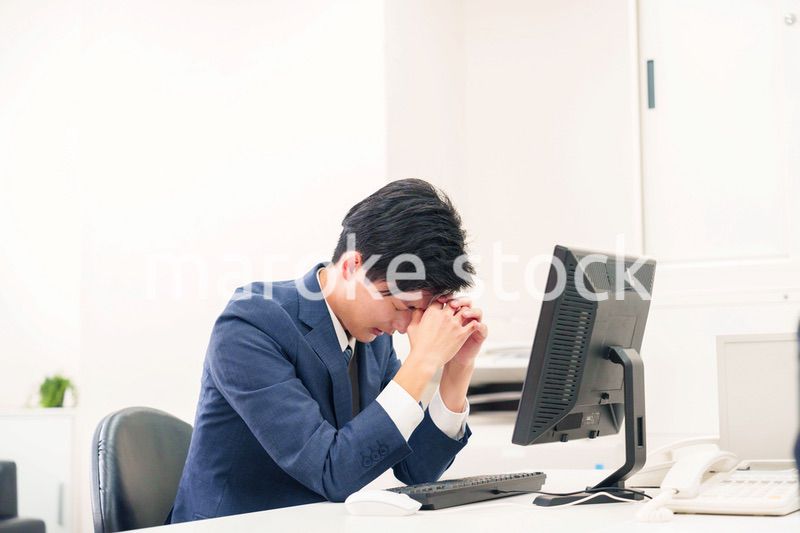 オフィスでドライアイに苦しむビジネスマン