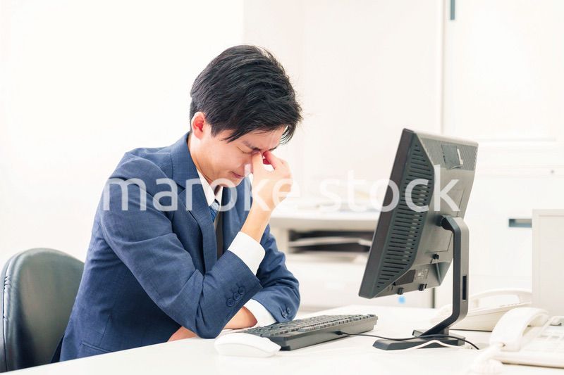 オフィスでドライアイに苦しむビジネスマン