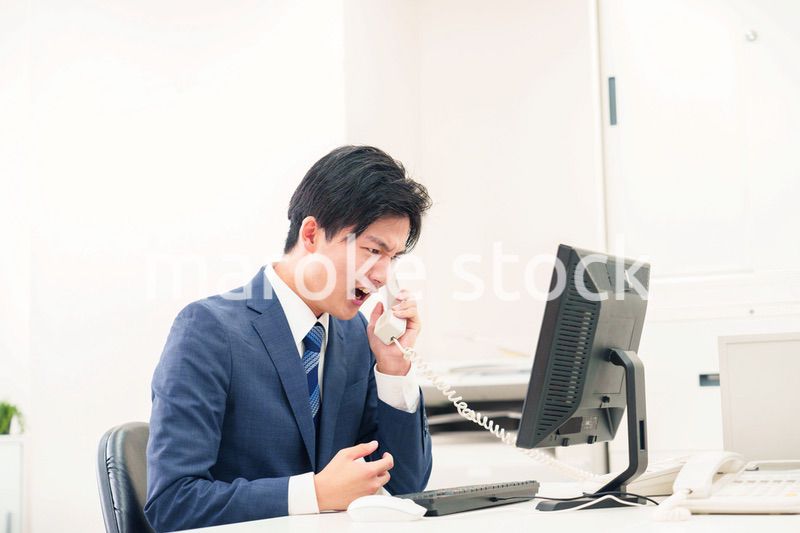 電話で怒鳴るビジネスマンの男性