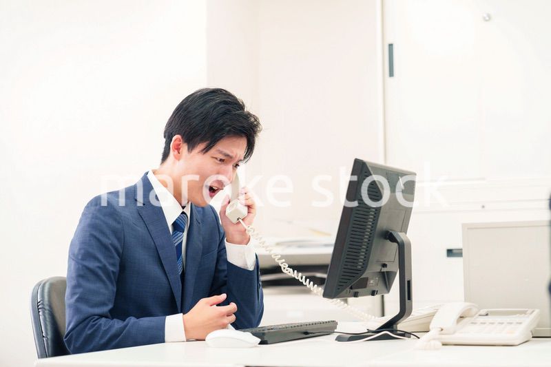 電話で怒鳴るビジネスマンの男性