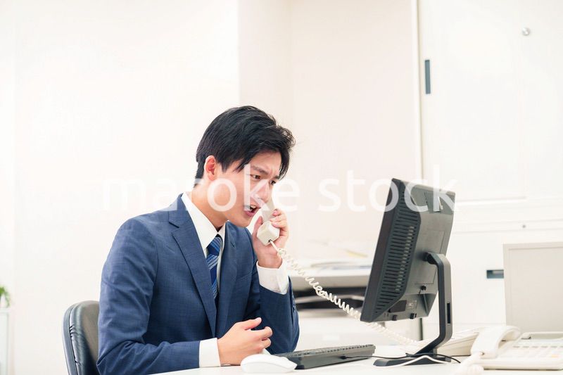 電話で怒鳴るビジネスマンの男性