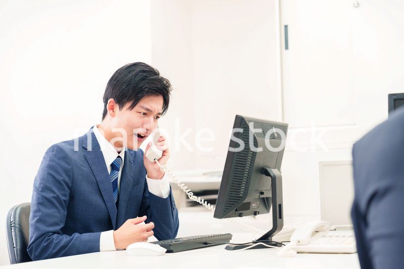 電話で怒鳴るビジネスマンの男性