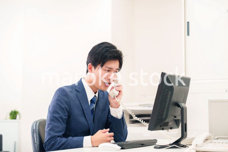 電話で怒鳴るビジネスマンの男性