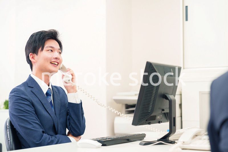 オフィスの電話で話すビジネスマン
