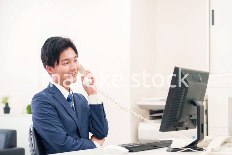 オフィスの電話で話すビジネスマン