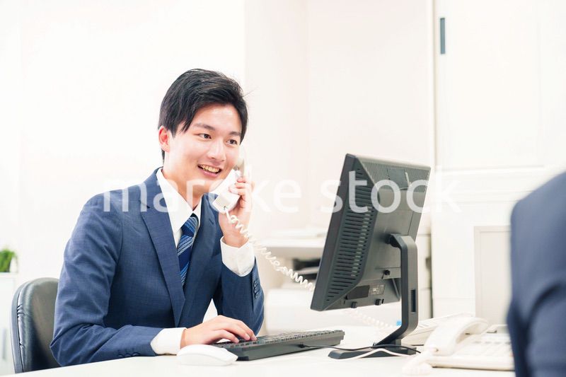 オフィスの電話で話すビジネスマン