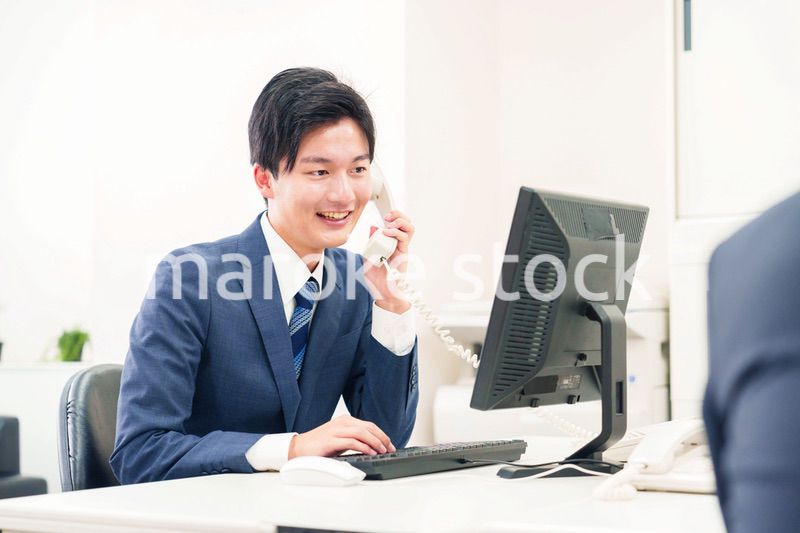 オフィスの電話で話すビジネスマン