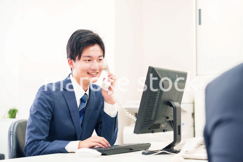 オフィスの電話で話すビジネスマン