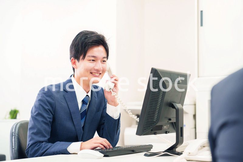 オフィスの電話で話すビジネスマン