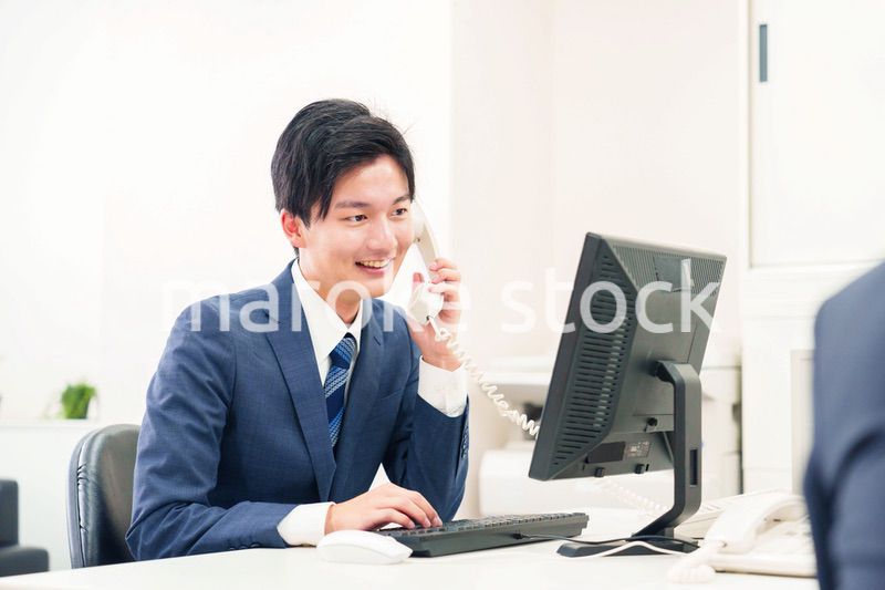 オフィスの電話で話すビジネスマン