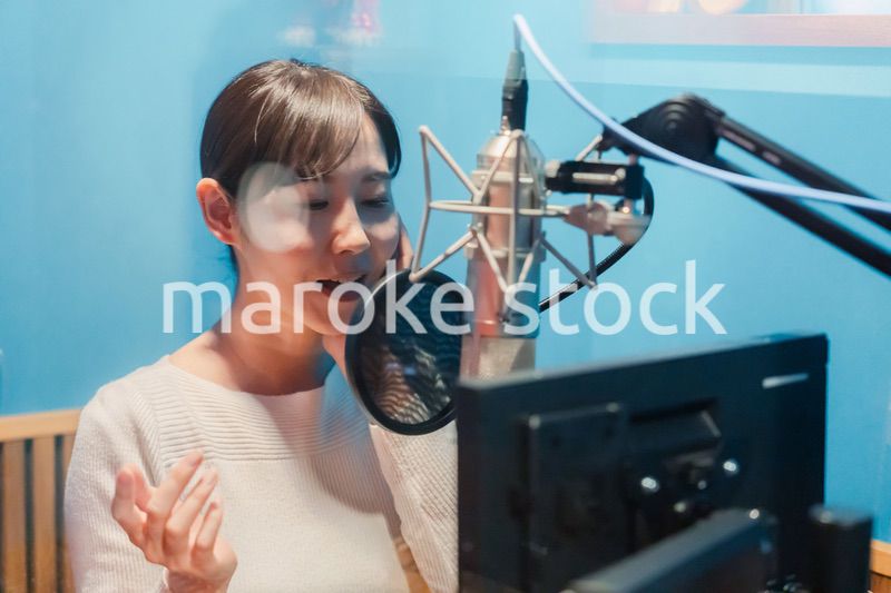 歌の収録をする若い女性