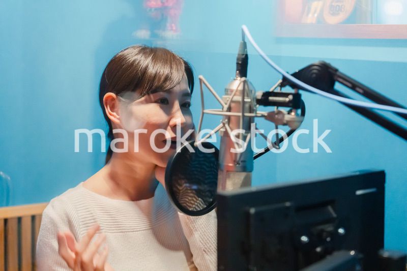 歌の収録をする若い女性