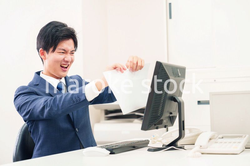 オフィスで書類を破り捨てるビジネスマン