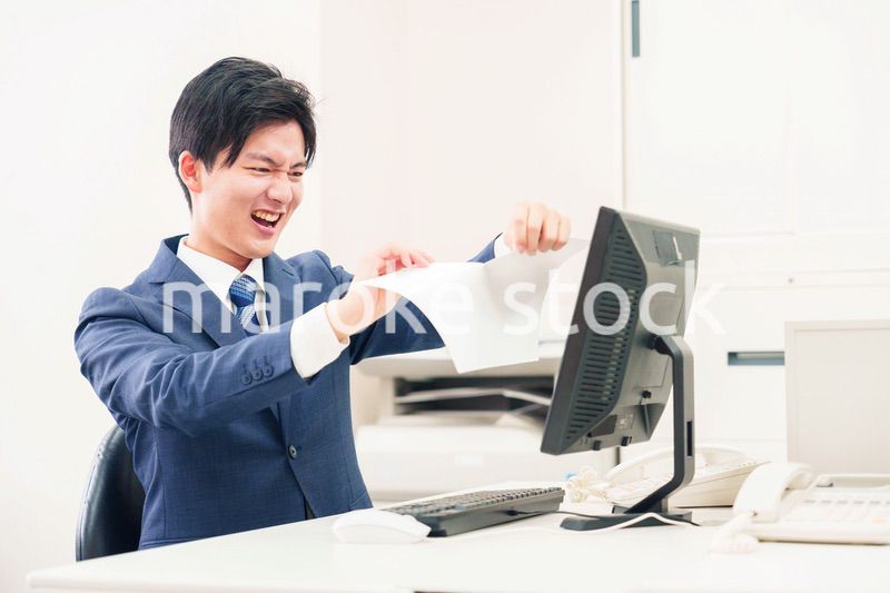 オフィスで書類を破り捨てるビジネスマン