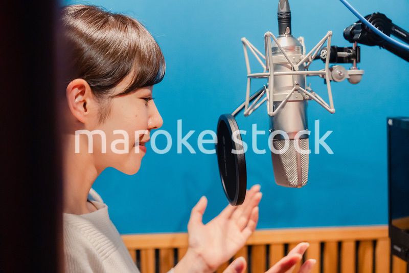 歌の収録をする若い女性