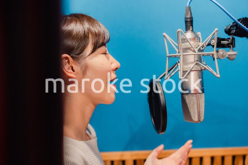 歌の収録をする若い女性