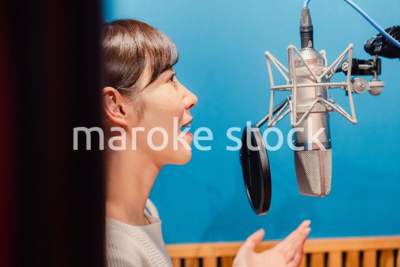 歌の収録をする若い女性