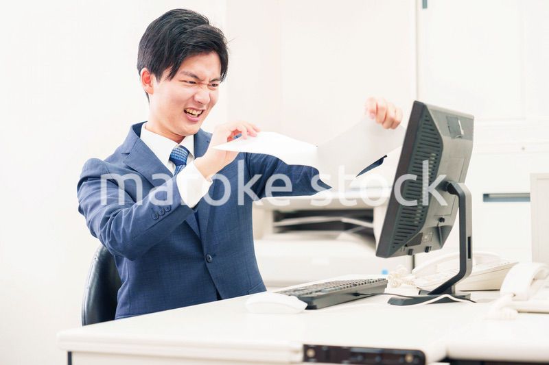 オフィスで書類を破り捨てるビジネスマン