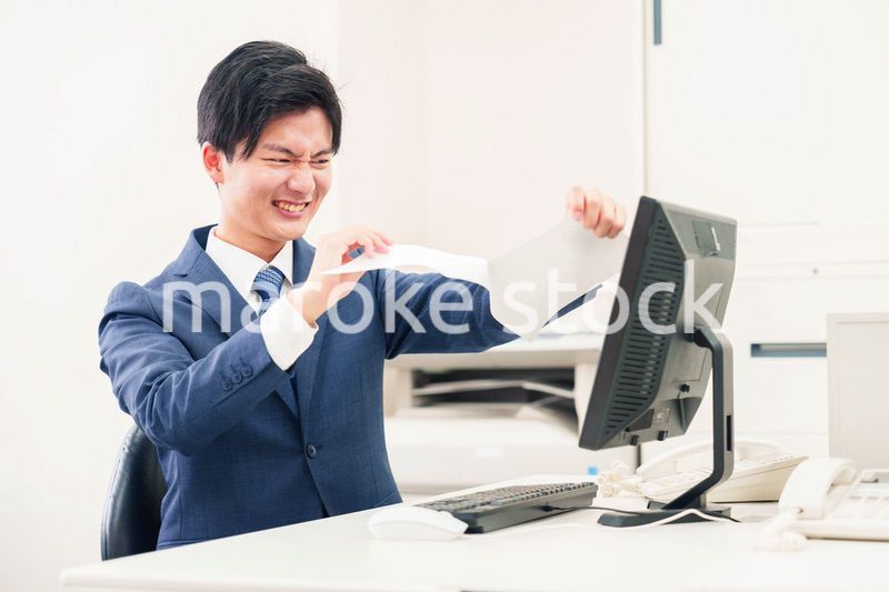 オフィスで書類を破り捨てるビジネスマン