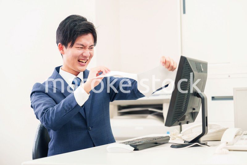 オフィスで書類を破り捨てるビジネスマン
