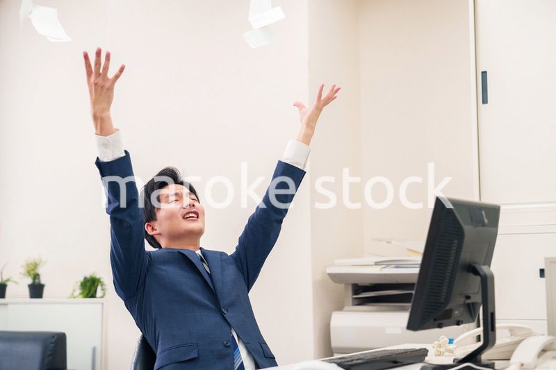 オフィスで書類を破り捨てるビジネスマン