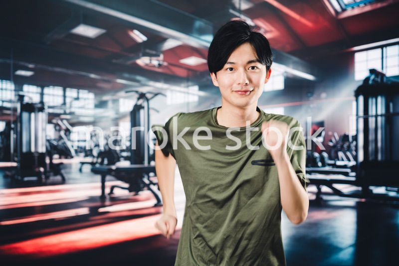 スポーツジムでランニングをする若い男性