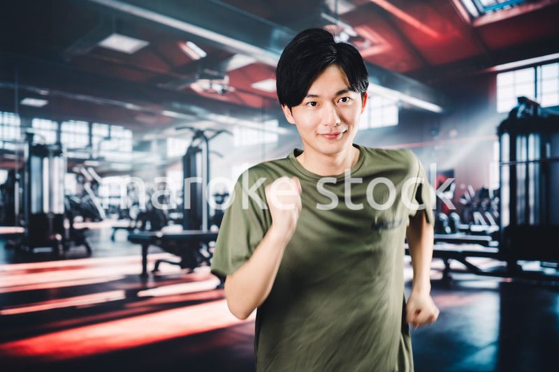 スポーツジムでランニングをする若い男性