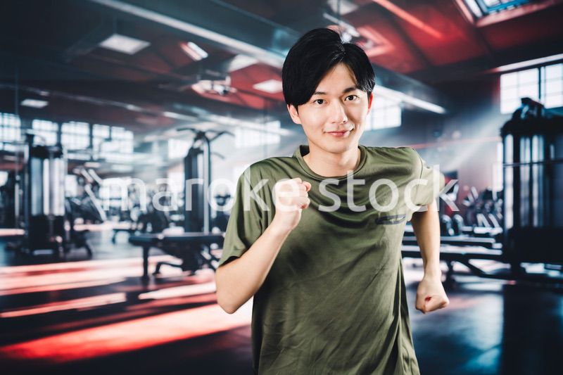 スポーツジムでランニングをする若い男性