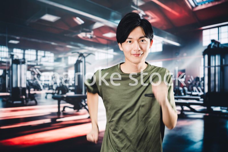 スポーツジムでランニングをする若い男性