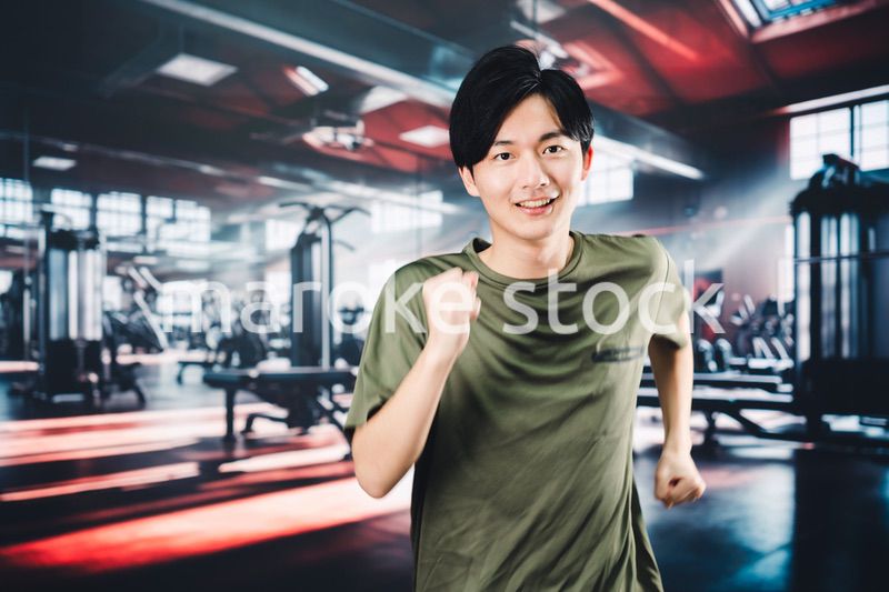 スポーツジムでランニングをする若い男性