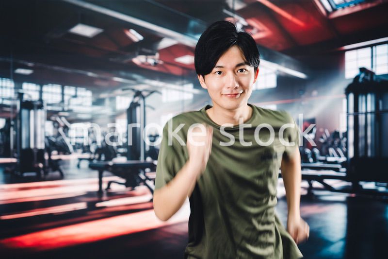 スポーツジムでランニングをする若い男性