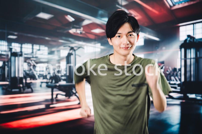 スポーツジムでランニングをする若い男性