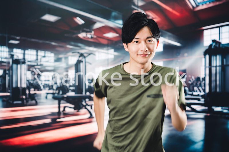 スポーツジムでランニングをする若い男性