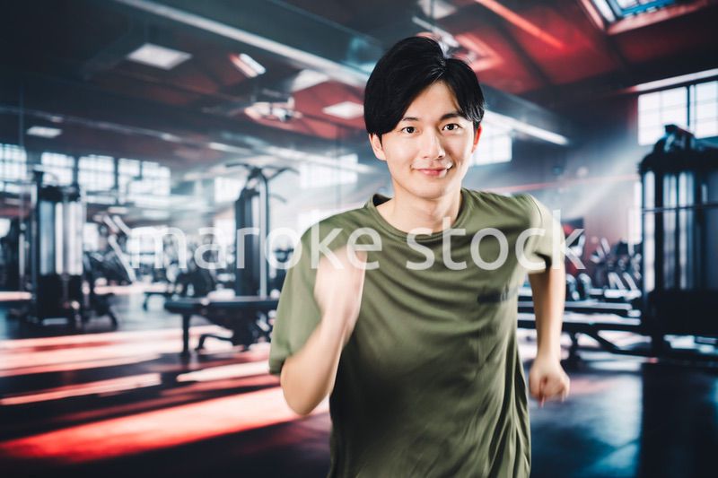スポーツジムでランニングをする若い男性