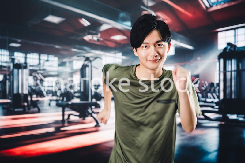 スポーツジムでランニングをする若い男性