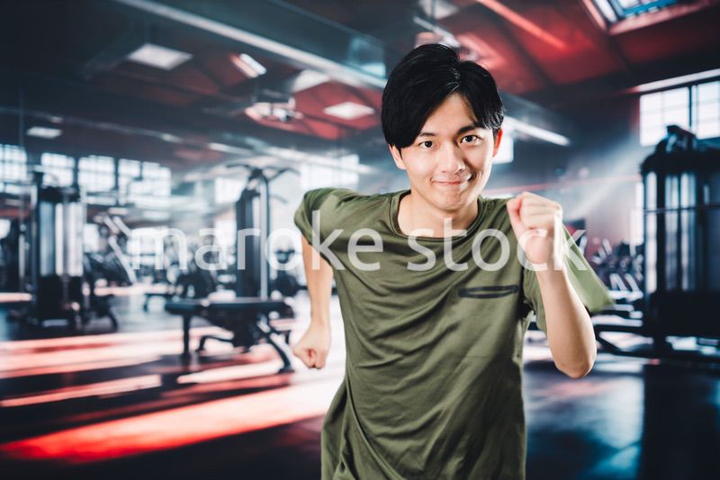 スポーツジムでランニングをする若い男性