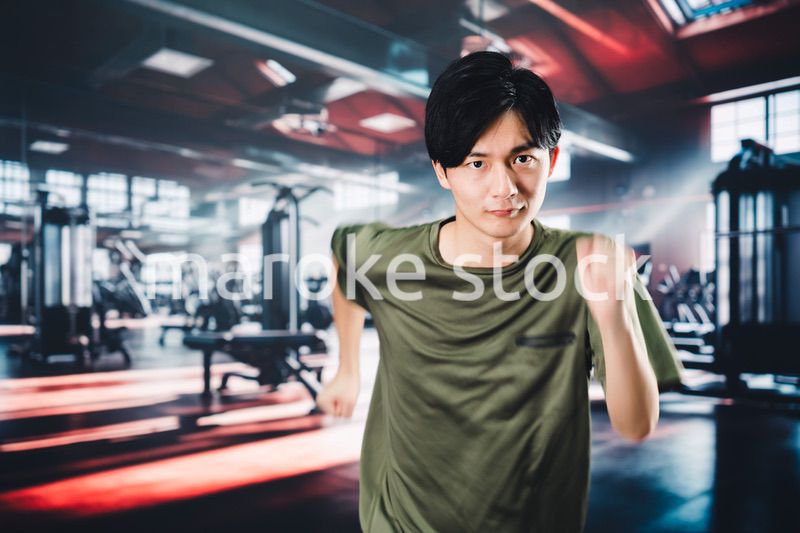 スポーツジムでランニングをする若い男性