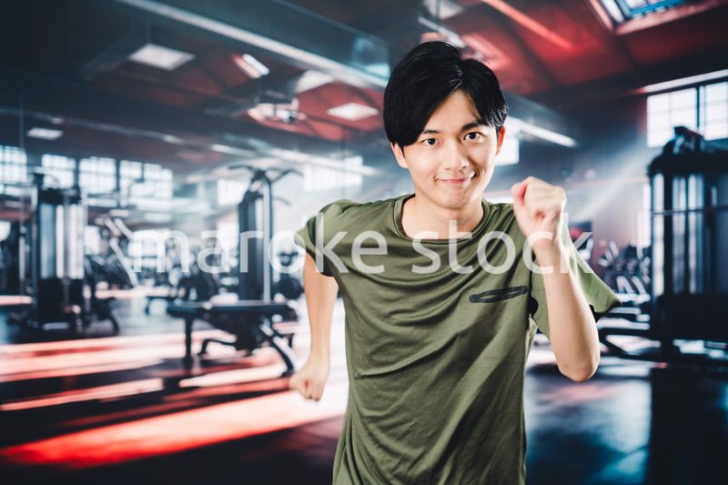 スポーツジムでランニングをする若い男性
