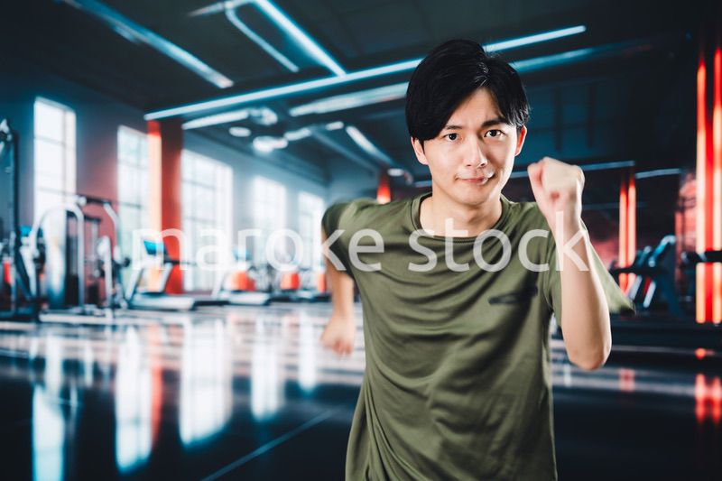 スポーツジムでランニングをする若い男性