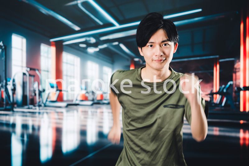 スポーツジムでランニングをする若い男性