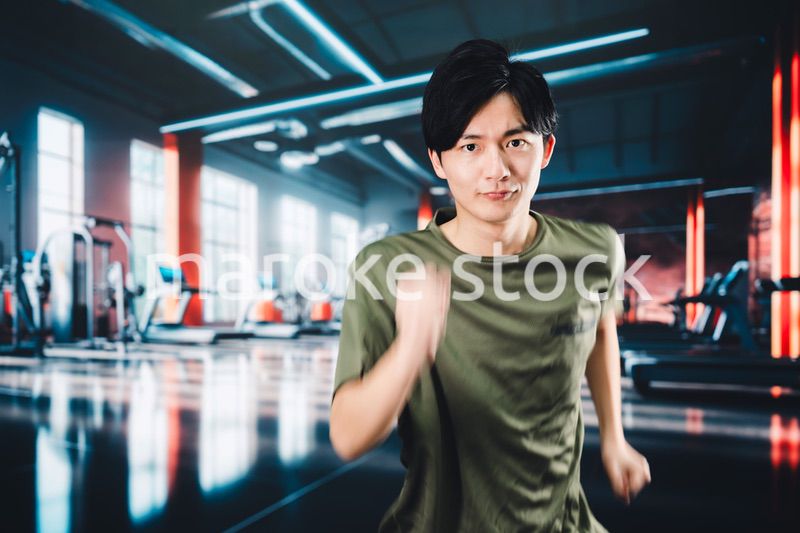 スポーツジムでランニングをする若い男性