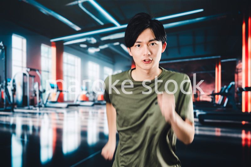 スポーツジムでランニングをする若い男性