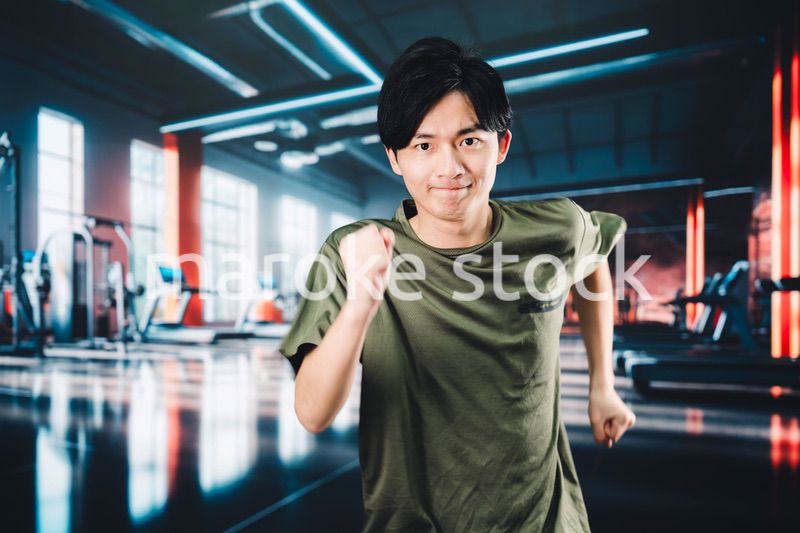 スポーツジムでランニングをする若い男性