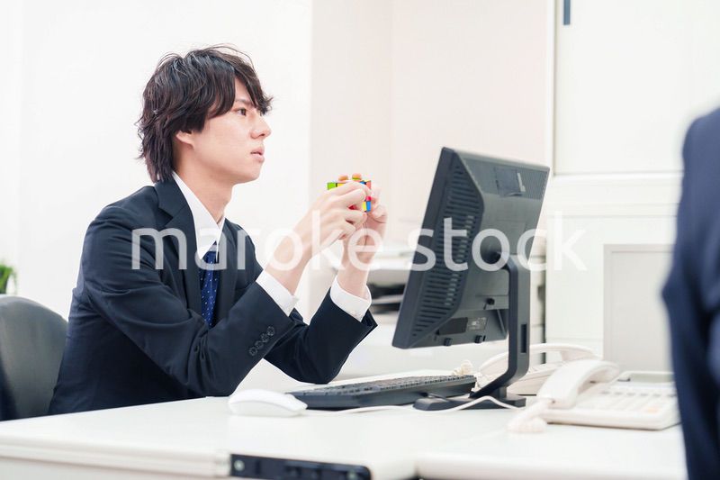 仕事中にルービックキューブをするビジネスマン