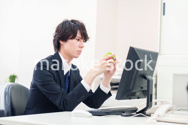 仕事中にルービックキューブをするビジネスマン