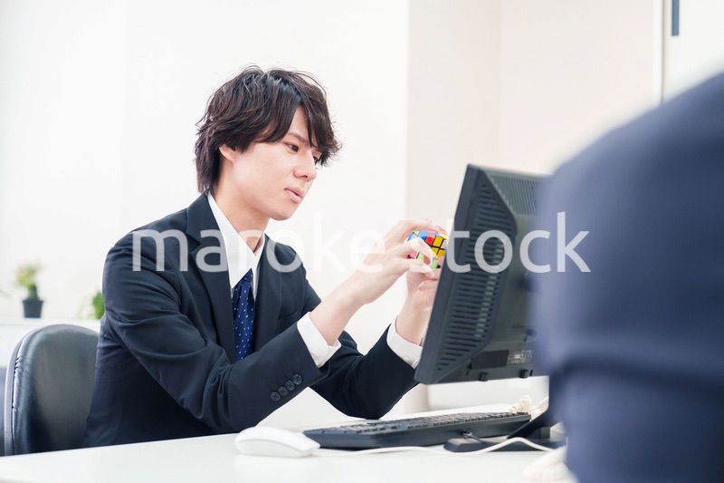 仕事中にルービックキューブをするビジネスマン