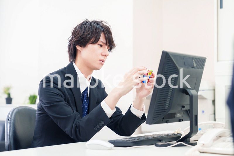 仕事中にルービックキューブをするビジネスマン