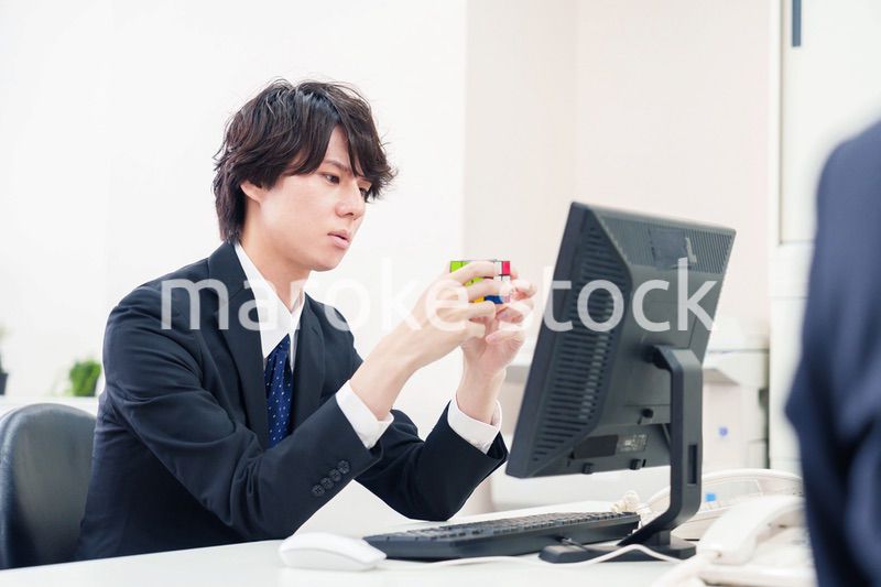 仕事中にルービックキューブをするビジネスマン
