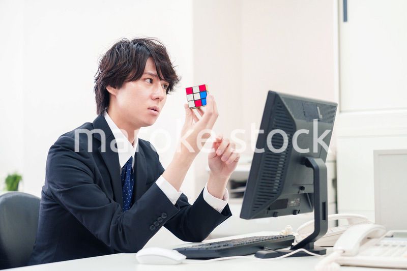 仕事中にルービックキューブをするビジネスマン