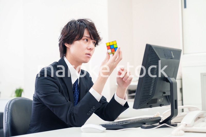 仕事中にルービックキューブをするビジネスマン